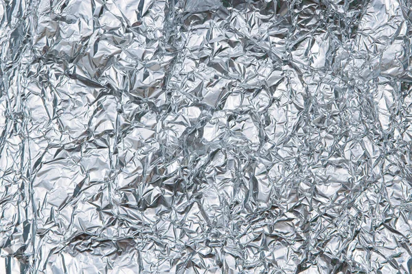 Zilverkleurige gerimpelde folie textuur achtergrond. Bovenaanzicht — Stockfoto