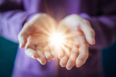 : Açık Ellerde Parlayan Işığı Tutan Kadın Güçlenmenin ve Paylaşmanın Sembolünü Verirken.