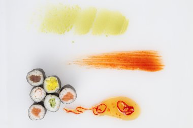 sushi rolls and sauce on white background clipart