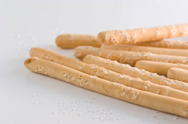 İtalyan ekmeği bir bardakta tuzlu bir masada.