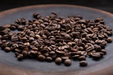 Kavrulmuş aromatik kahve çekirdekleri masaya serpilmiş.