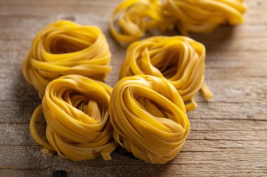 Ev yapımı makarna eski ahşap arka planda yuvalara sarılmış.