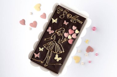 Çikolata kalplerle çevrili beyaz bir arka plan için 8 Mart 'ı kutlayan el yapımı neşeli çikolata kartı.