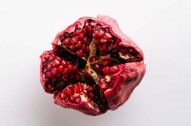 Beyaz arkaplanda olgun nar kesimi, yakın çekim üst görünüm