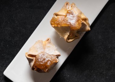 Beyaz düz tabakta tatlı kekler ve koyu arkaplan