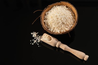 Hindistan cevizi tanecikleri siyah arkaplanda hindistan cevizi kabuğunda