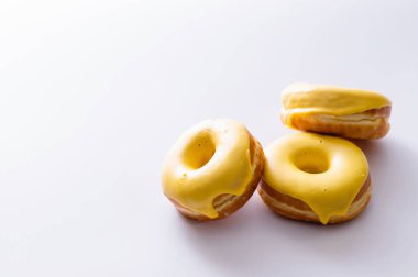 Beyaz arka planda muz dolgulu üç çörek, lezzetli bir kahvaltı, neşeli bir ruh hali, mesaj için yer.