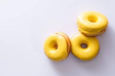 Beyaz arka planda muz dolgulu üç çörek, lezzetli bir kahvaltı, neşeli bir ruh hali, mesaj için yer.