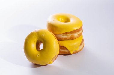 Beyaz arka planda muz dolgulu üç çörek, lezzetli bir kahvaltı, neşeli bir ruh hali.