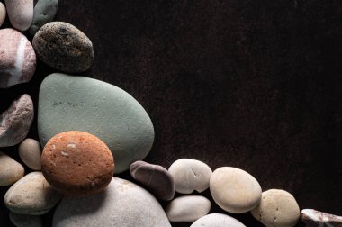 Koyu arkaplanda bir çerçeve şeklinde deniz taşları