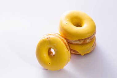 Beyaz arka planda muz dolgulu üç çörek, lezzetli bir kahvaltı, neşeli bir ruh hali.