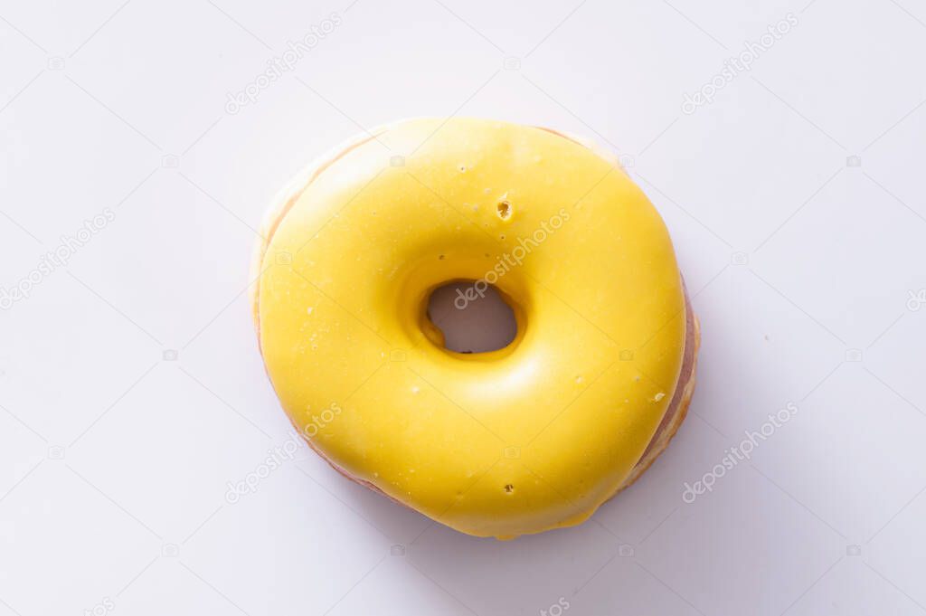 donut with banana filling lies on a white background, delicious breakfast, bright mood, close-up
