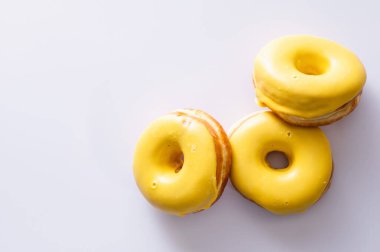 Beyaz arka planda muz dolgulu üç çörek, lezzetli bir kahvaltı, neşeli bir ruh hali, mesaj için yer.