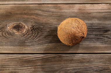 Olgun hindistan cevizi ahşap bir masada yatıyor, metin için yer var.