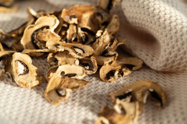 Kurutulmuş mantar şampiyonları, parlak gün ışığında masaya saçılmış, boş, yarı bitmiş ürün, pişirmeye katkı sağlıyor.