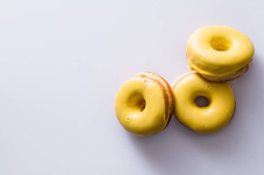 Beyaz arka planda muz dolgulu üç çörek, lezzetli bir kahvaltı, neşeli bir ruh hali, mesaj için yer.