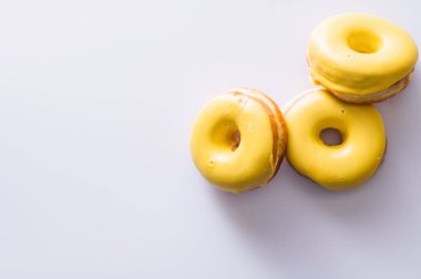 Beyaz arka planda muz dolgulu üç çörek, lezzetli bir kahvaltı, neşeli bir ruh hali, mesaj için yer.