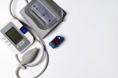 Beyaz arkaplanda tonometre ve nabız oksimetresi