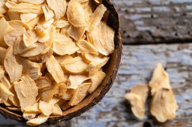 Hindistan cevizi kabında gevrek kokulu kuru sarımsak eski ahşap bir arka planda, yakın plan, üst manzara