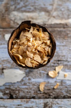 Hindistan cevizi kabında gevrek kokulu kuru sarımsak eski ahşap bir arka planda, yakın plan, üst manzara