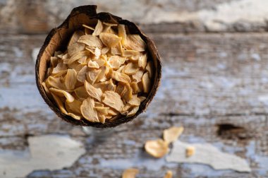 Hindistan cevizi kabında gevrek kokulu kuru sarımsak eski ahşap bir arka planda, üst manzara, metin için boş alan