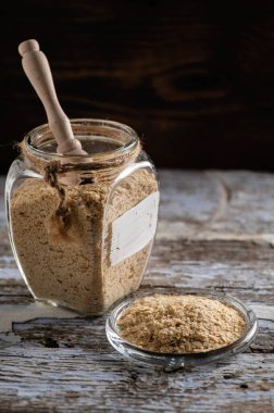 Taneli besin maya, devre dışı bırakılmış, canlı değil, B vitamini, bir kavanozda ahşap arka planda, yakın plan, yan görüş