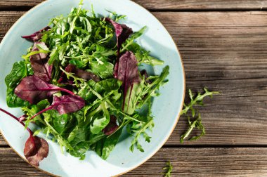 Taze otların salata karışımı, roka, İsviçre pazısı, tarenle 'de ahşap bir arka planda ıspanak, serhu manzarası