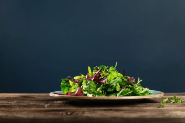 Taze otların salata karışımı, roka, pazı, tarenle 'de ıspanak ahşap arka planda, yan görüş, metin için boş alan