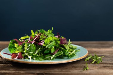 Taze otların salata karışımı, roka, pazı, tarenle 'de ıspanak ahşap arka planda, yan görüş, metin için boş alan