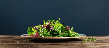 Taze otların salata karışımı, roka, pazı, tarenle 'de ıspanak ahşap arka planda, yan görüş, metin için boş alan