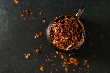 Kuru doğranmış domates, baharat, bir tabak için malzeme, kahverengi bir kabın içinde, dağınık parçalar, gri bir taş zemin üzerinde, metin için boş alan