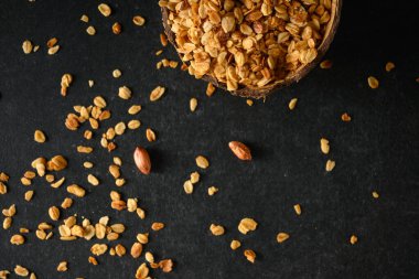 Hindistan cevizi kasesinde fındıklı ev yapımı granola, koyu gri arka plan, üst manzara.