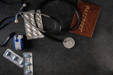 Nabız oksimetresi, kan oksimetresi, elektronik termometre, pasaport, tonometre, gri arka planda haplar, üst görüş, metin için boş alan
