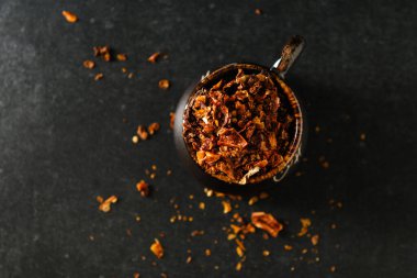 Kuru doğranmış domates, baharat, bir tabak için malzeme, kahverengi bir kabın içinde, dağınık parçalar, gri bir taş zemin üzerinde, metin için boş alan