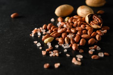 yer fıstığı, kuru yer fıstığı, ceviz, Himalaya kaba tuzu koyu gri arka planda, mesaj için boş alan