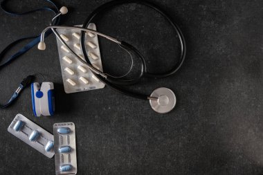 Nabız oksimetresi, kan oksimetresi, elektronik termometre, tonometre, gri arka planda haplar, üst görüş, metin için boş alan