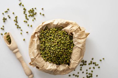 Beyaz arka planda, üst tarafta, el işi kağıdında kuru fasulye, yakın plan.