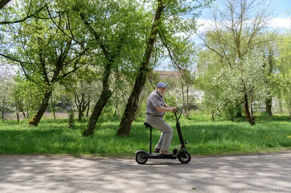 Een Positieve Charismatische Oudere Man Rijdt Een Eco Scooter Het — Stockfoto