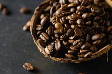 Hindistan cevizi kabında kahve çekirdekleri koyu gri arka planda, yakın plan.,