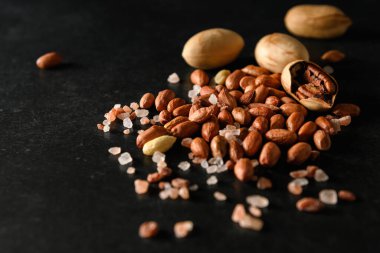 yer fıstığı, kuru yer fıstığı, ceviz, Himalaya kaba tuzu koyu gri arka planda, mesaj için boş alan