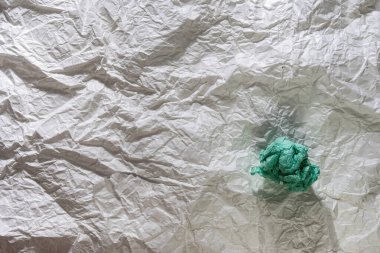 Buruşmuş beyaz ambalaj kağıdının deseni ve buruşuk gök mavisi bir kağıt topu.