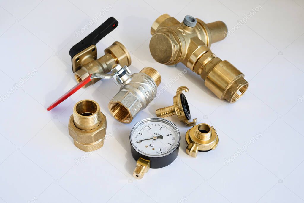 Brass accessories for water supply, water supply and irrigation: pressure gauge, fittings, on a light gray background