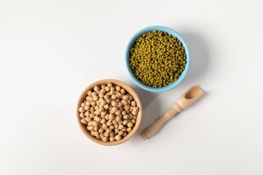 Kuru nohut, yeşil fasulye, beyaz bir masada seramik bir tabakta.