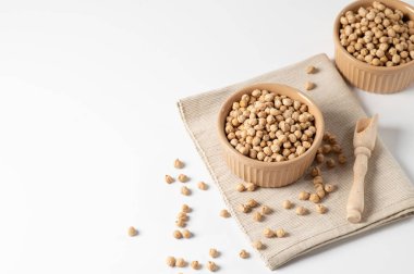 Nohutlar kuru, beyaz bir masada seramik bir kasede, mesaj için boş bir yer.