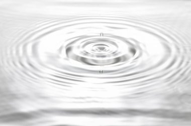 Düşen damlalar, sıçramalar, dalgalanmalar yüzünden suyun üzerinde daireler çiziyor.