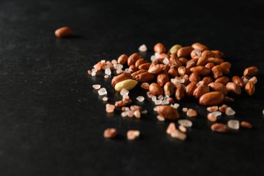 yer fıstığı, kuru yer fıstığı, Himalaya kaba tuzu koyu gri arka planda, mesaj için boş alan