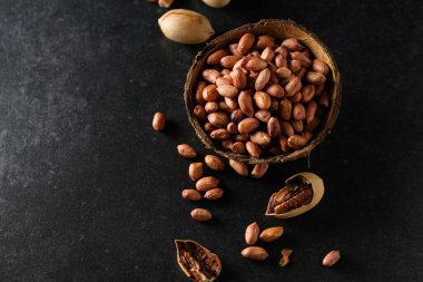 fıstıklar, kuru fıstıklar, fındıklar hindistan cevizi kasesinde koyu gri arka plan, üst manzara, mesaj için boş alan