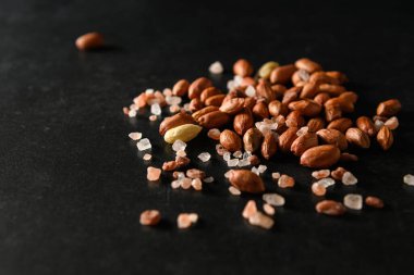 yer fıstığı, kuru yer fıstığı, Himalaya kaba tuzu koyu gri arka planda, mesaj için boş alan