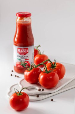 Rivne, Ukrayna, 05 / 08 / 2021, Passata Di Pomodoro Mazza domates püresi, beyaz arkaplanda kırmızı domatesler