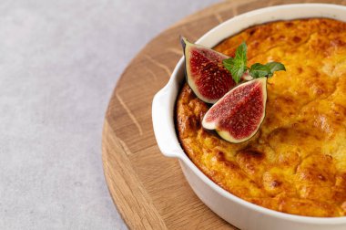 Tahta üzerinde yuvarlak beyaz şekilli balkabağı güveci, açık gri masa, incirle süslenmiş, restoran servisi, büyük